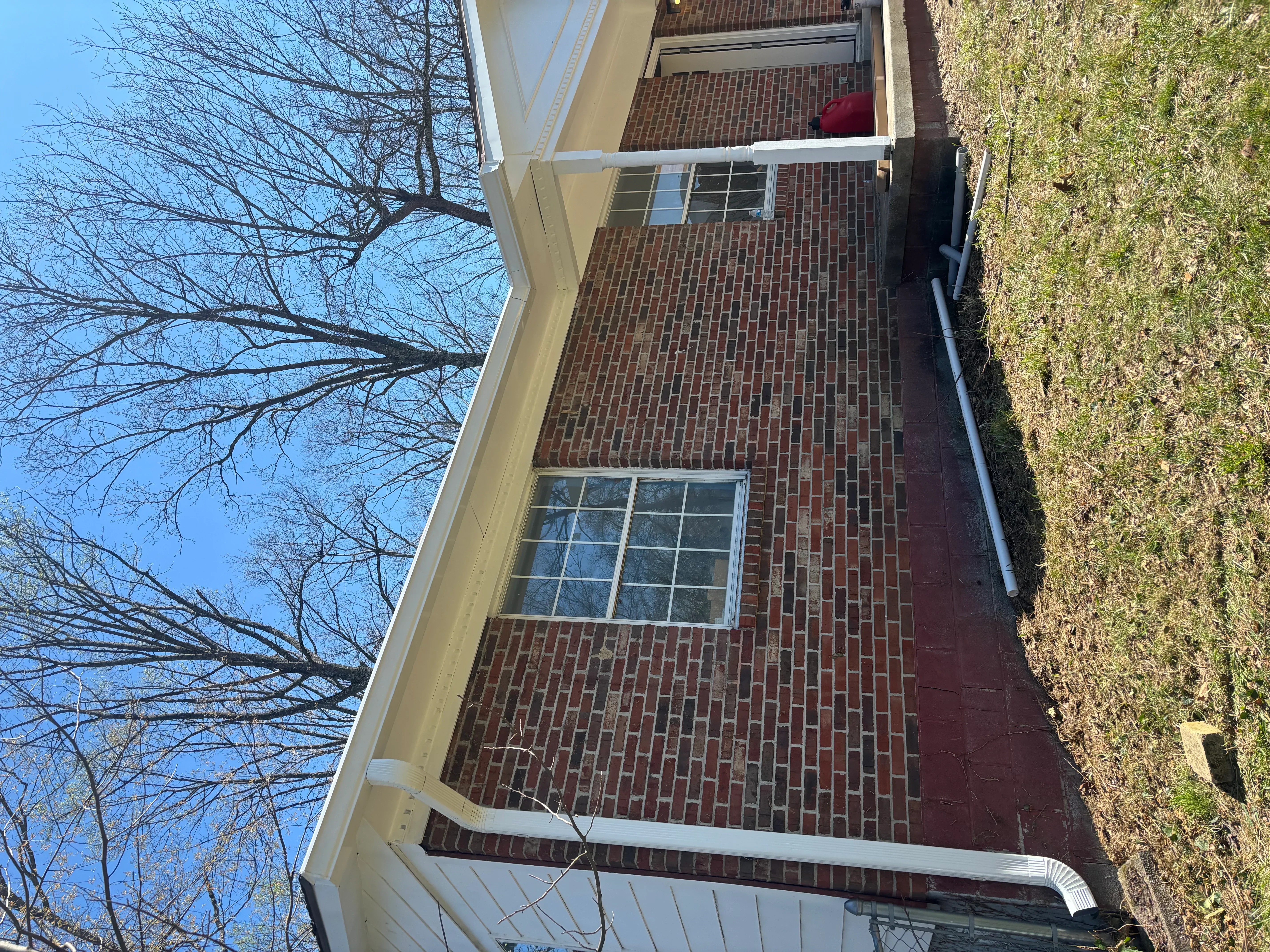 White aluminum gutters installed on brick home with downspout and fascia trim