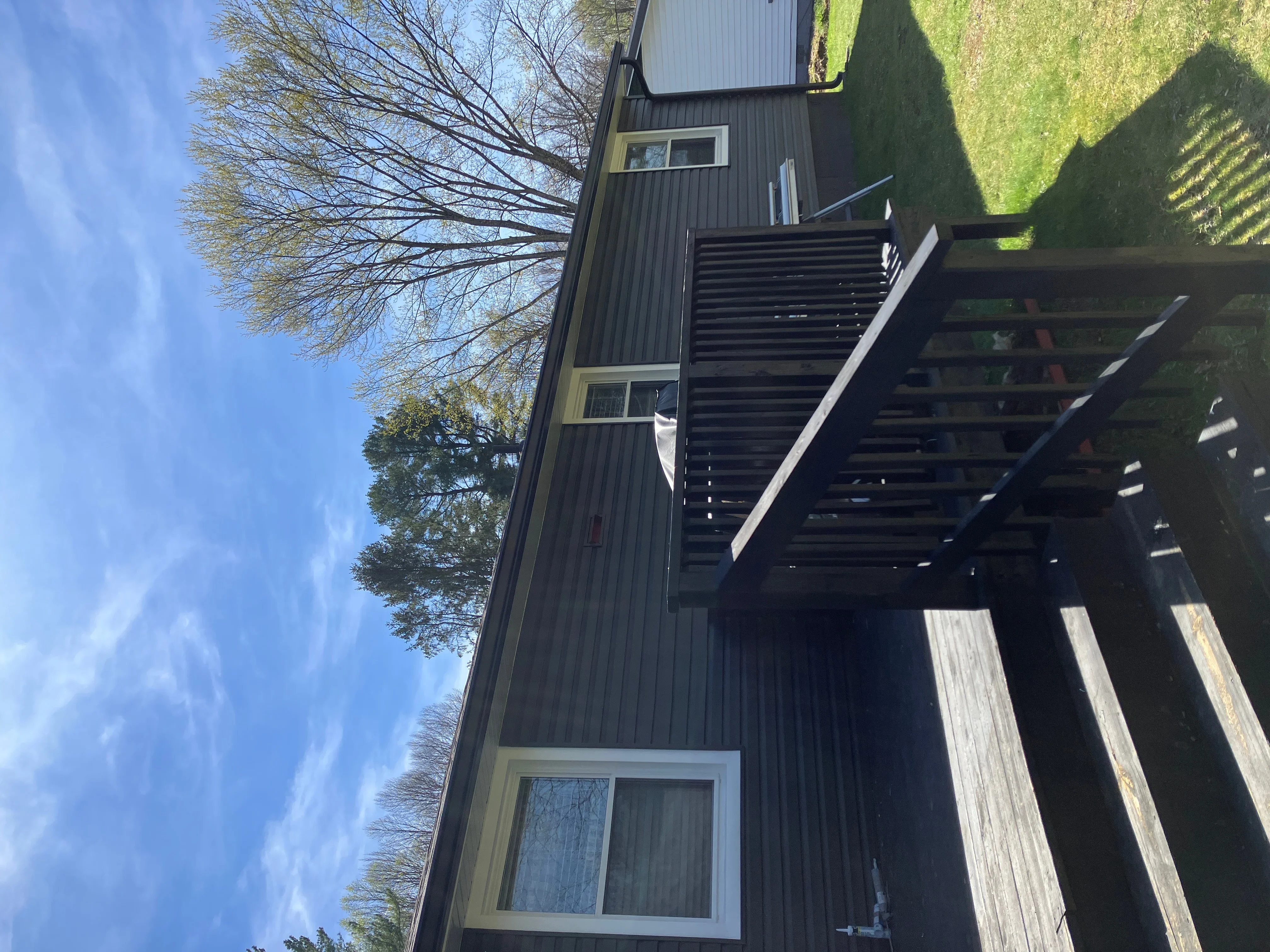 Black metal gutters with white fascia on corrugated metal sided home